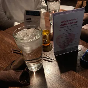 a glass of water and a menu