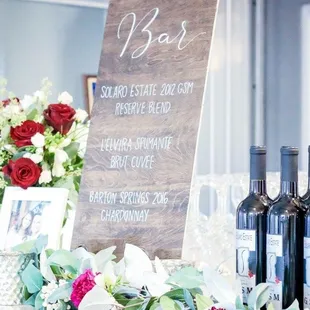 a table with wine bottles and flowers