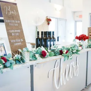 a bar decorated with flowers and greenery