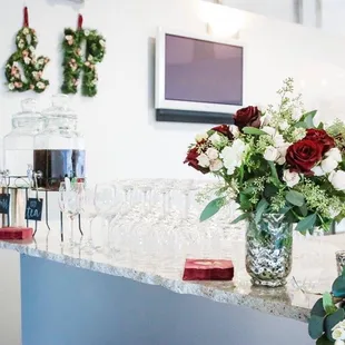 a bar with wine glasses and flowers