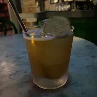 a cocktail with a lime slice in it