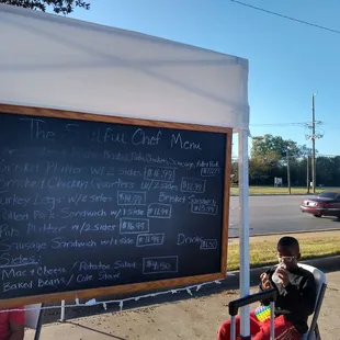 a man sitting in front of a chalkboard
