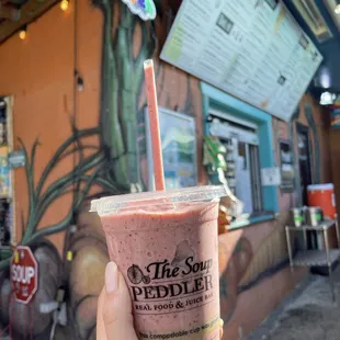 a hand holding a smoothie