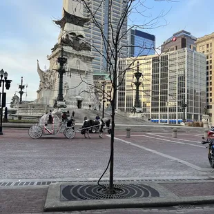 a horse drawn carriage in a city square