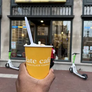 a hand holding a cup of coffee