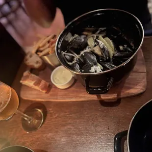 a bowl of mussels and a glass of beer