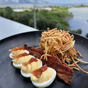 bacon, eggs, and hash browns on a black plate