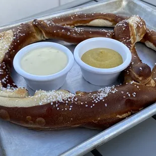 Warm pretzel with queso sauce and Dijon mustard