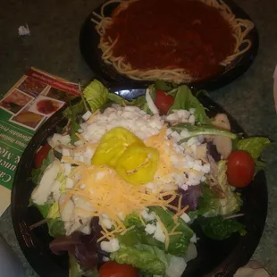 Grilled Chicken salad... Chicken tasted fake..frozen and thawed. Speghetti and meat sauce in the background