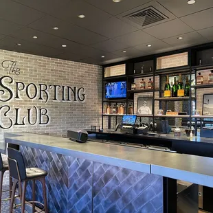 a bar with chairs and a television