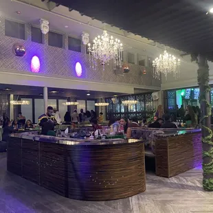 a bar with chandeliers hanging from the ceiling