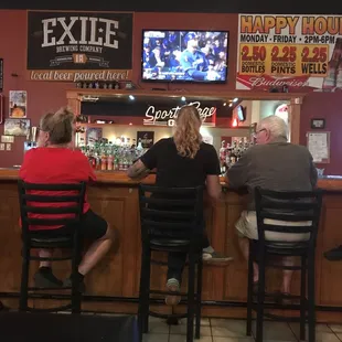 three people sitting at a bar