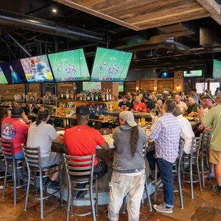  a large group of people sitting at the bar