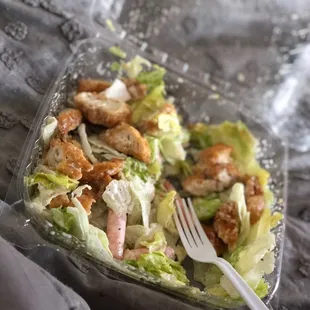 a plastic container with a salad in it