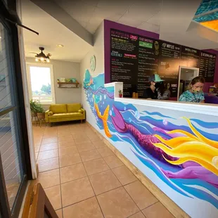 a restaurant with a colorful mural on the wall
