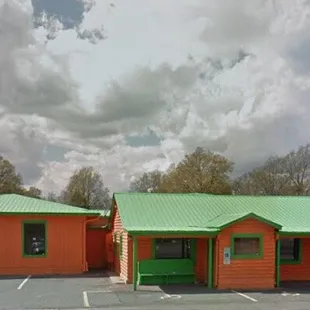 a parking lot with two orange and green buildings