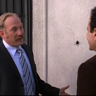 a man in a suit talking to another man