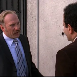 a man in a suit talking to another man