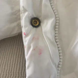 a bed with white sheets and a black button