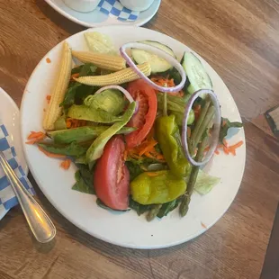 a plate of salad and a bowl of dips