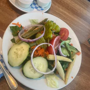 a plate of salad and a bowl of dips