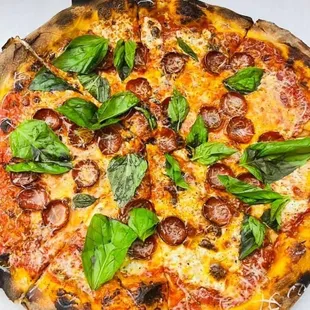 Pepperoni pie with some fresh basil.