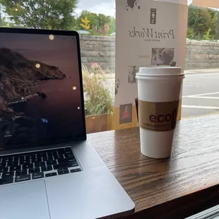 a cup of coffee next to a laptop