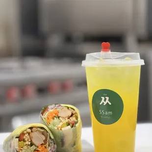 a glass of juice and a vegetable wrap