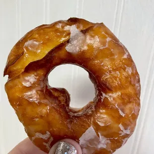 a hand holding a glazed donut