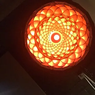 a lit candle in a circular light fixture