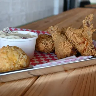 a tray of fried chicken with a side of coleslaw