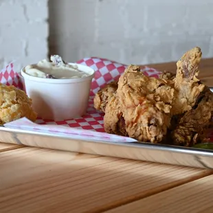 a tray of fried chicken with a side of dip