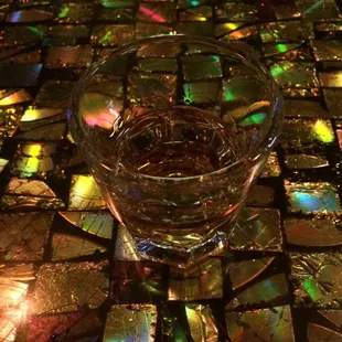 a glass of water on a mosaic table