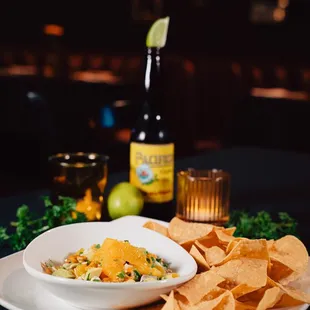 a bowl of chips and a bottle of beer