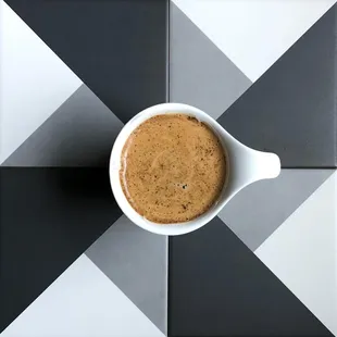 a cup of coffee on a tiled floor