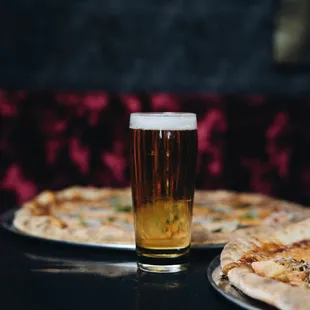 two pizzas and a glass of beer