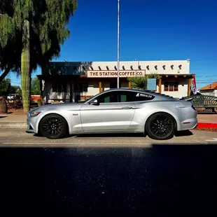 a silver mustang parked in a parking lot