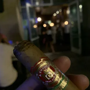 a hand holding a cigar