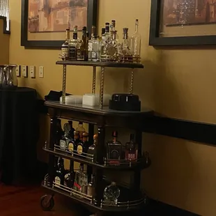 a bar cart with liquor bottles on it