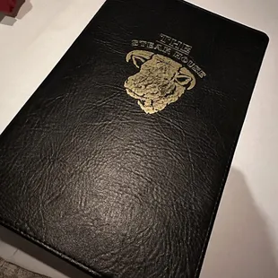 a black menu book on a table