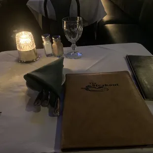 a table setting with a menu and wine glasses