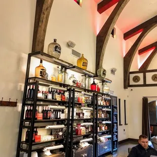 a man sitting on a chair in front of a wine rack