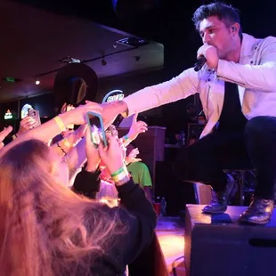 a man standing on a stage with his hands in the air