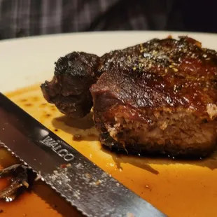 a steak and a knife on a plate