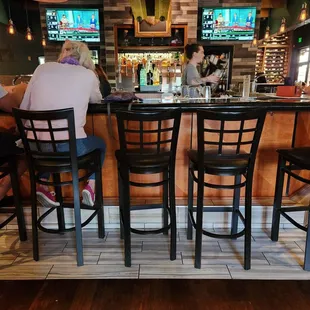 hree people sitting at a bar
