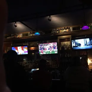 people watching televisions in a bar