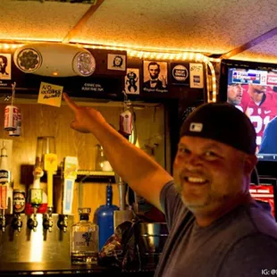 a man holding up a ticket in front of a bar