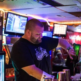 a man pouring a drink at a bar