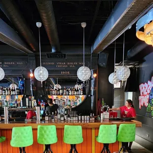 a bar with neon green chairs