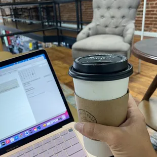 a hand holding a cup of coffee